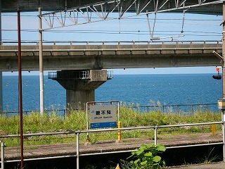 駅名標と海