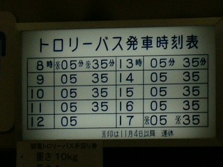 電灯式の白地に濃い青で書かれたトロリーバスの小さな時刻表