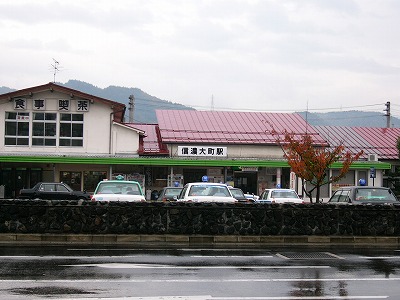 赤い屋根の平屋の駅舎。左には2階建ての食事処が連結されている。