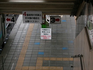 正方形の敷石を詰められたホーム、左側には列車が停車中。