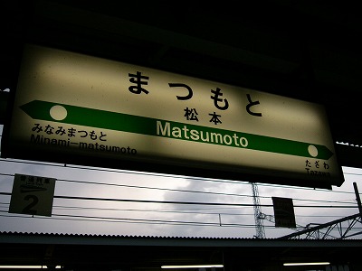 屋根からつるされる「まつもと」の電灯式駅名標