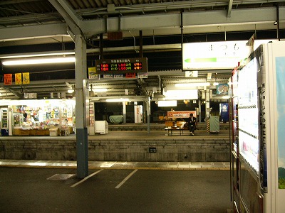 ホームを横に見て。向こうにはさらに2つのホームがある。自動販売機や駅名標の明かり