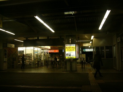 暗闇の中に電灯式広告と改札口とその明かり