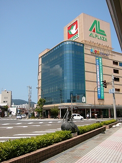 モカ色の建物で、かどを含む左側面は濃いメタリックブルーのガラス張りになっている。