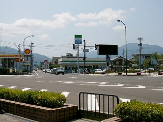 水色の空に一筋の薄い雲。大きな交叉点だが、全体的に向こう側は賑わっていない。