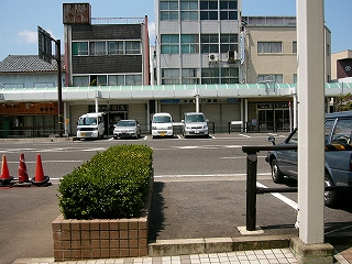 反対側の歩道のアーケードに鉛直に並んだ自動車4台。