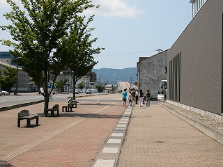 広々とした道路。ずっと向こうに登りの橋。左手に低くて四角い建物が少しある。