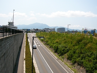 下にもぐりこむ道路を見下ろして。左はコンクリートの壁面、右手は雑草の茂る土手。