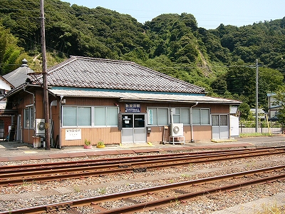 ごつい瓦葺の平屋の建物。壁は薄茶のトタン。