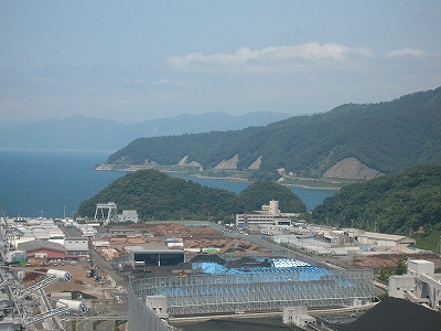 ずっと遠くの海岸沿いの道路。ところどころ低い山の斜面を法面にしてあるのが見える。