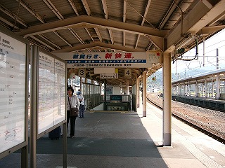 暗いベージュの上屋の下に吊り下げられた横長の「敦賀行き、新快速」の宣伝看板。その奥の方に下りの階段が口をあけている。