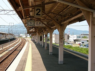 暗いベージュの上屋の下の風景。ホーム上には何もおかれておらず、左には線路と隣のホームが見える。