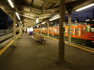 草津線ホームのようす。上屋は真新しいＶ字型で、幅の広いホームの真ん中には一人掛けのいすが連ねて置かれている。ずっと奥の方に明るい自販機。