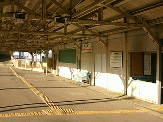 幅広いホームの床面とホームに面した駅舎の壁と断面が三角の上屋。