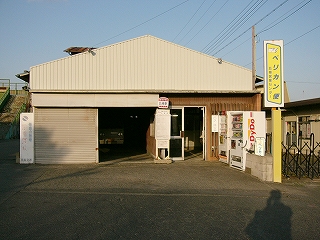 妻型の屋根の単純な白い建物。