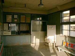 くすんだ色をした汚れた木の壁の室内。床はコンクリート打ち放し。