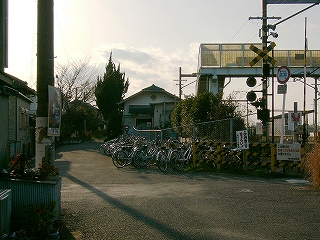 踏み切り、自転車、跨線橋、駅舎。