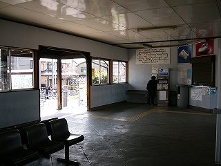 左手の駅舎出入口の間口にこげ茶色の木が見えている。