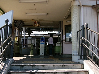 階段の途中から改札口を見上げて。駅舎内は少し暗い。