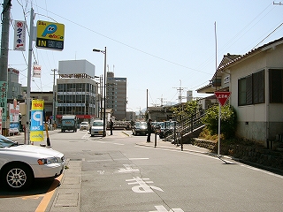小さなビル、民家、1.5車線の道路。