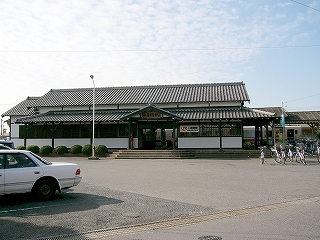 回廊の屋根と建物本体の屋根で二重になったの屋根の駅舎を正面から見て。どっしりとした横長。