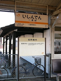上に上屋から吊り下げられた無灯式駅名標、その下にはホームに立つ名所案内。