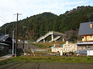 少し高い土手の上にある駅の跨線橋を見上げて。