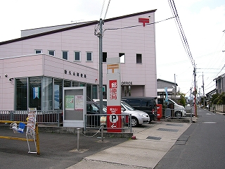 ピンク色の二階建ての局舎。屋根の隅がとがっている。