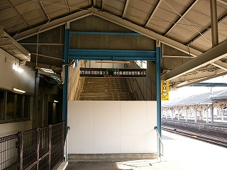 下半分だけ白い板で封鎖された階段の上り口。