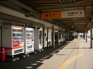 左斜めに改札口前を見て。3台の自動販売機、そしてキヨスクの窓口、そして自動改札の並び。人は誰もいない。