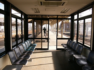 ほぼ前面ガラス張りの真新しい待合室。両脇に椅子があるだけ。