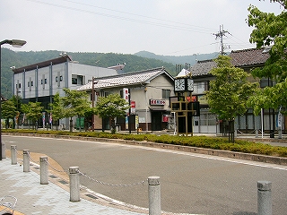 細長い緑地帯をもつロータリー。向こう側には3軒ほどの建物が立ち並んでいる。