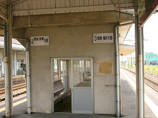 古ぼけたコンクリート造りの待合室入口のある面。