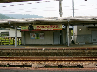 向かいのホームの上屋から、こちら側に向けて吊られた横長の看板。