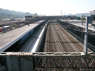 4線の新幹線構内。遠くにそれを跨ぐ跨線橋がある。