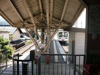 柵が半円になった古い改札ブースの向こうに延びる島式ホーム。ホームの上屋も木造。