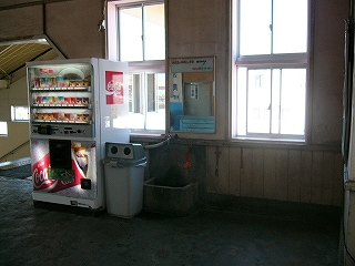 私道販売機と、随分古い水場。水場の上には明るい窓がある。