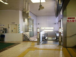 改札内に入ってすぐ左にある下り線ホームへの階段とエスカレーター。天井からは自動改札の方を向いたカメラが5台もまとまって吊られている。