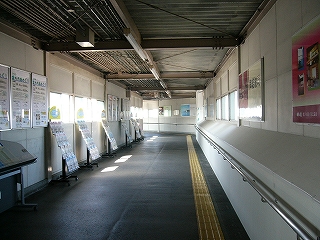 断面がほぼ四角形の通路。床面はアスファルトで、天井は高く厚みのある鼠色の波板になっている。両脇の壁は白色で間隔を置いて窓が設置され、ときどき大きな横長の広告が現れる。全体的に少し薄暗い。