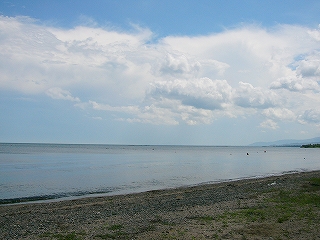 非常に緩やかで薄い波の打ち寄せる浜辺。浜辺は小石が荒い。