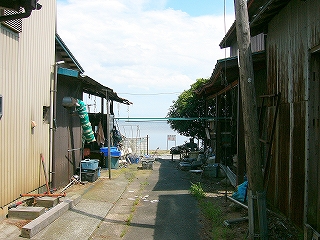 民家と民家の少し広い間から垣間見える湖面。