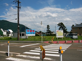 短い横断歩道の向こうに芝生の広い敷地。