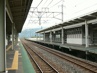 線路内に向かって少し上ずった陸屋根の上屋の駅構内。全体的に鉄骨と波板で作られ、色も白と灰色で仮設のような感じがある。