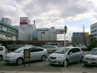 自動車が並んで斜めに停められた駅前。