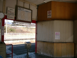 シャッターで閉じられた出札口。改札口上部には時刻表が掲示されている。