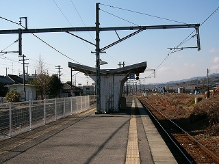 Ｖ字型の屋根を持つ木造の白い待合所。