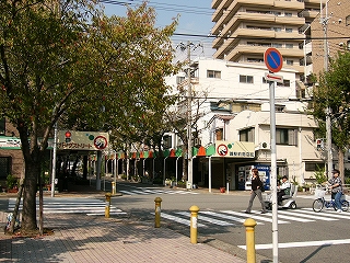 道の両脇の歩道に簡単な屋根の付いた商店街。右の歩道の屋根の始まる所に「パンタストリート」、左の歩道の屋根の始まる所に「灘駅前商店街」と書かれている。