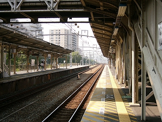 左に上屋のある下り線ホーム、中央に上り線ホームの2番線が一直線に伸びる。駅を抜けてレールがずっと遠くまで続いているのも見える。