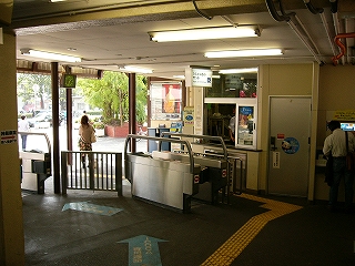 一台の自動改札と有人改札。改札を出ればすぐ野外で、緑の木が見えている。