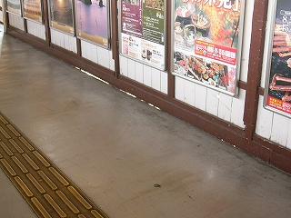 灰色の壁と焦げ茶の壁の横柱との間にできたわずかな隙間。